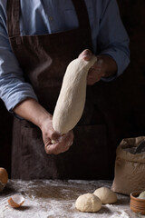 Baker chef man kneading dough bread and bakery ingredients for homemade cooking at table