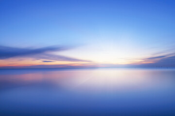 Obraz na płótnie Canvas Calm blue colored sea and clear sky at sunset