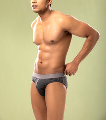 Cropped shot of muscular young man wearing underwear isolated on white background. 