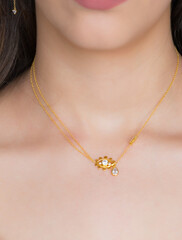 Young woman wearing a golden necklace and golden earrings. Beautiful valentine's gift.