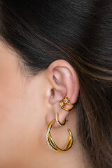 Woman ear with mulriple piercings wearing beautiful earrings with zirconia.  Beautiful valentine's...