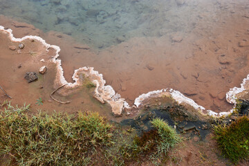 The shore of a hot reservoir formed by geysers in Iceland in the valley of the geyser Strokkur
