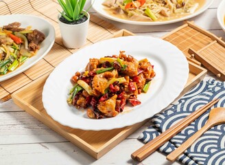 Kung Pao Chicken with chilli served in a dish isolated on wooden tray and napkin side view of taiwan food