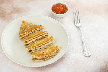 Christmas and New year tree shaped pancakes or crepes with red caviar decorations on light colored background. Holiday homemade food. Flat lay top view. Christmas food for children and kids.