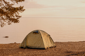 tent in nature on the shore of a lake or sea. vacation travel and weekend solitude. a trip out of town to wild places, tourism and recreation for a traveler and an altpinist. spend the night in an