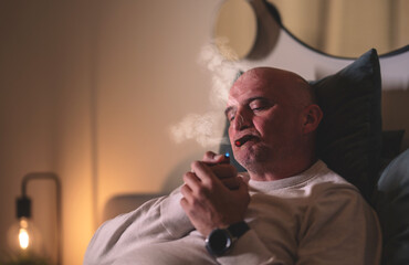 A man lights a cigar in a relaxed atmosphere in his room
