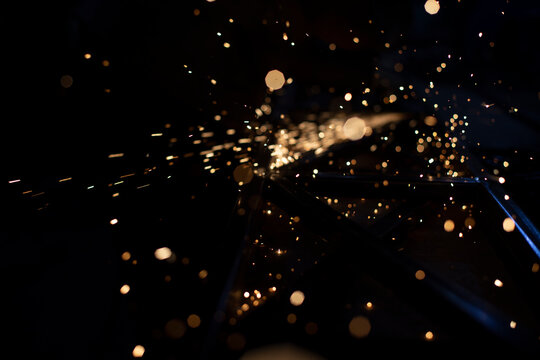 Sparks In Dark. Stream Of Lights On Black Background. Metal Crushing. High Temperature.