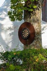 Alte Holz Dart Scheibe hängt draußen an einem Baum