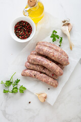 Uncooked barbeque sausage on packing paper and spice cooking food