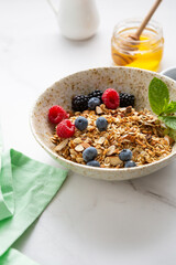 grains granola with nuts in white bowl breakfast food concept blueberry