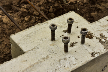 Close up of concrete foundation with anchor bolts and reinforcement rod ready for continued construction.