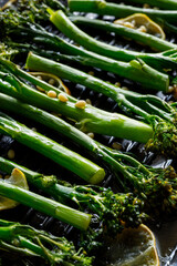 Grilled broccoli in lemon marinade sprinkled with pine nuts on the grill plate, close up view