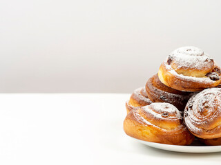 Gluten-free buns made of rice and corn flour with cinnamon, raisins and cranberries. The concept of proper nutrition, gluten-free diet, healthy home baking. On a light background.