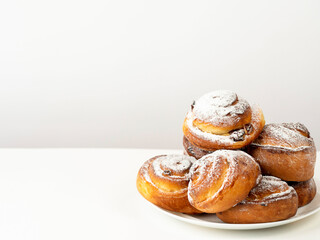 Gluten-free buns made of rice and corn flour with cinnamon, raisins and cranberries. The concept of proper nutrition, gluten-free diet, healthy home baking. On a light background.