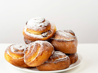 Gluten-free buns made of rice and corn flour with cinnamon, raisins and cranberries. The concept of proper nutrition, gluten-free diet, healthy home baking. On a light background.