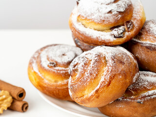 Gluten-free buns made of rice and corn flour with cinnamon, raisins and cranberries. The concept of proper nutrition, gluten-free diet, healthy home baking. On a light background.