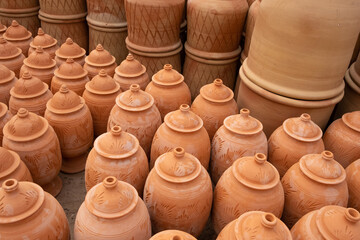 Fototapeta na wymiar Handmade traditional ceramic pottery made of white and orange clay in small familiar factory 