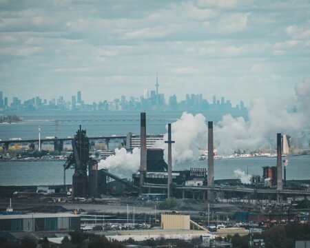 Fototapeta Smoke coming out from Hamilton factories with the Skyway bridge and Toronto skyline