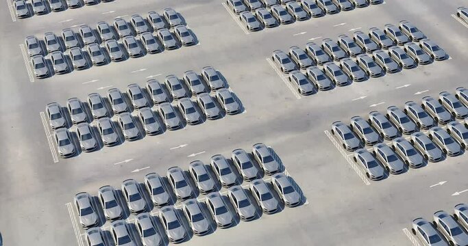 Aerial view of new electric sports cars on a huge car dealer parking lot. Multiple rows of self driving cars ready for import and export business. New cars in storage for sale. Realistic 3d animation