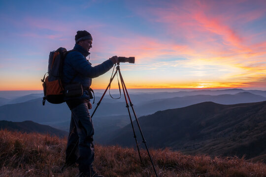 Landscape photographer with the tripod at the sunset