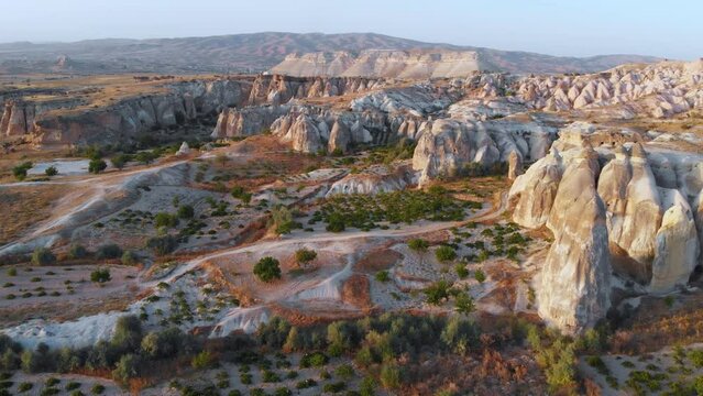 Cappadocia aerial drone sunset view to Cappadocia valleys, rock formation, ancient cave churches. Goreme, Cappadocia, Turkey