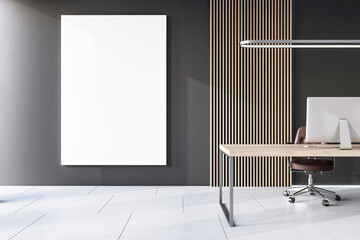 Front view on blank white poster with space for your logo or text on dark wall in stylish cabinet with slatted wall decor, wooden table with modern computer and concrete floor. 3D rendering, mock up