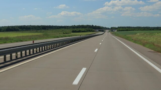 Road view on a summer day. Highways and cars, roadside and white road line markings.