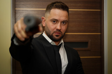 Male killer with a pistol with a silencer.