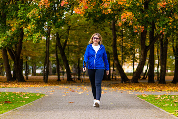 Nordic walking - woman training in city park
