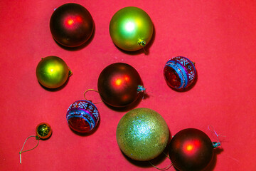 a notebook with emerging letters with the inscription New year on a red background with colorful Christmas balls and toys. Mockup for New Year's holiday design with copy space. new year's stop motion