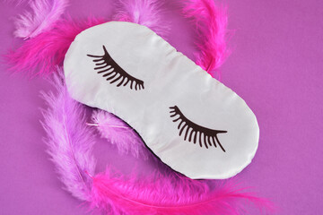 Top view silk sleeping mask and feathers copyspace