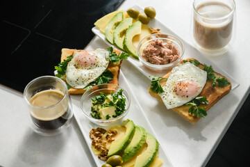 Fried egg with toast, parsley, sliced avocado, butter on a white plate. Morning breakfast. Top view.