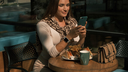 The girl holds a mobile phone in her hands and dials a number