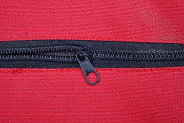 one black long zip on the red fabric of the bag © butus