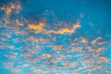 Fototapeta na wymiar Yellow clouds at sunset in the blue sky