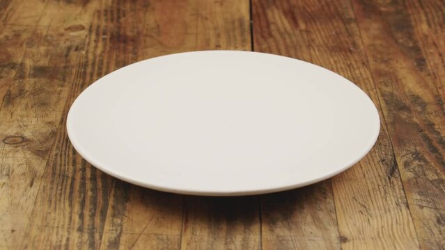 Gros plan d'une main de femme prend rapidement le dernier bonbon fraise dans une assiette blanche