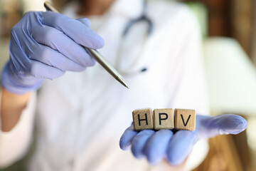 Doctor hands holding wooden cubes with word hpv