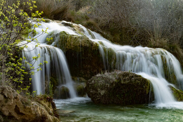 waterfall with silky effect in waters of turquoise and green tones in lagoons with trees and bushes in autumn tones