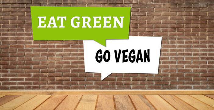 message EAT GREEN GO VEGAN on a brick wall