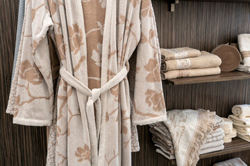 New clean bathrobes are hanging on hangers in the spa salon. Clean towels and aroma candles in the aromatherapy room. A shop selling towels and and bath robes. Exhibition of Cotton goods