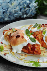 croissant with sweet cream and almonds on a plate. Delicious and healthy breakfast