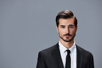 Portrait of a business man in a stylish suit with tie beautiful face on a gray isolated background. Business concept young businessman startup copy space