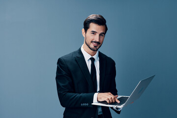 Man business smile looks into laptop and works online via internet in business suit video call business talks on blue background copy place