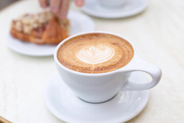 Cappuccino and almond croissant for breakfast 