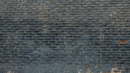 Horizontal part of dark brick wall background. Exterior wide old stone bricks