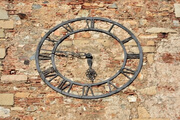 Reloj medieval en una fachada de ladrillo y roca