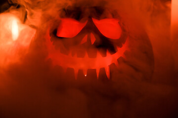 Fototapeta premium Halloween's holiday attributes. Halloween. carved pumpkin. candles . smoke . dark scene. pumpkin head silhouettes.