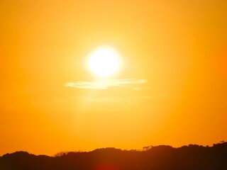 Por do sol com céu alaranjado em uma tarde de verão na Barra do Una, Peruíbe, São Paulo