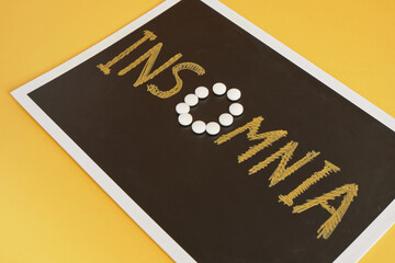 insomnia concert, the inscription insomnia on black chalk board on an orange background, pills instead of the letter o,