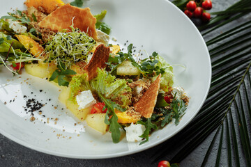 Summer diet salad with leaves of lettuce, watermelon, peach and feta cheese. On a light blue background copy space